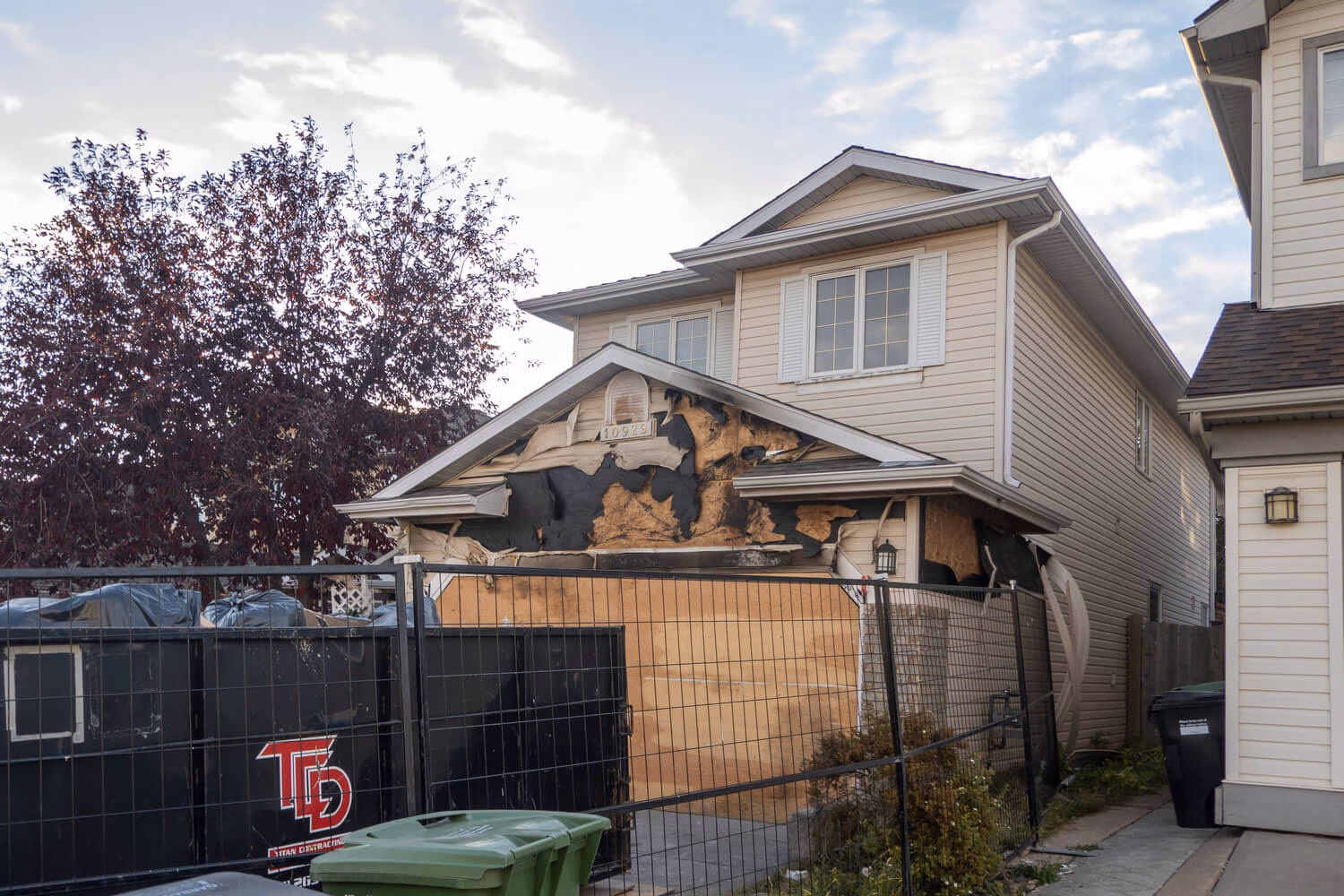Fire-damaged home exterior secured after the fire, showing one of the early stages that affects how long does fire damage restoration take.